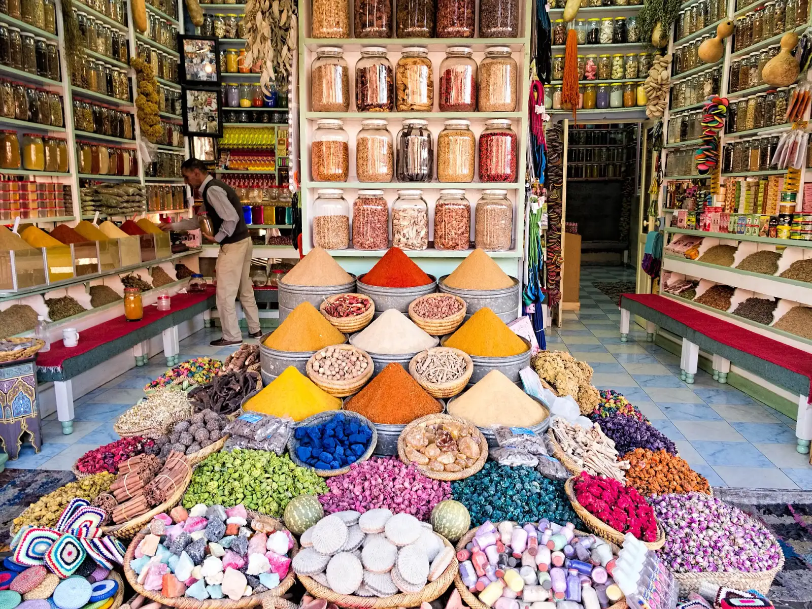 A spice shop in a Moroccan souk, cones of coloured spices stacked in the doorway