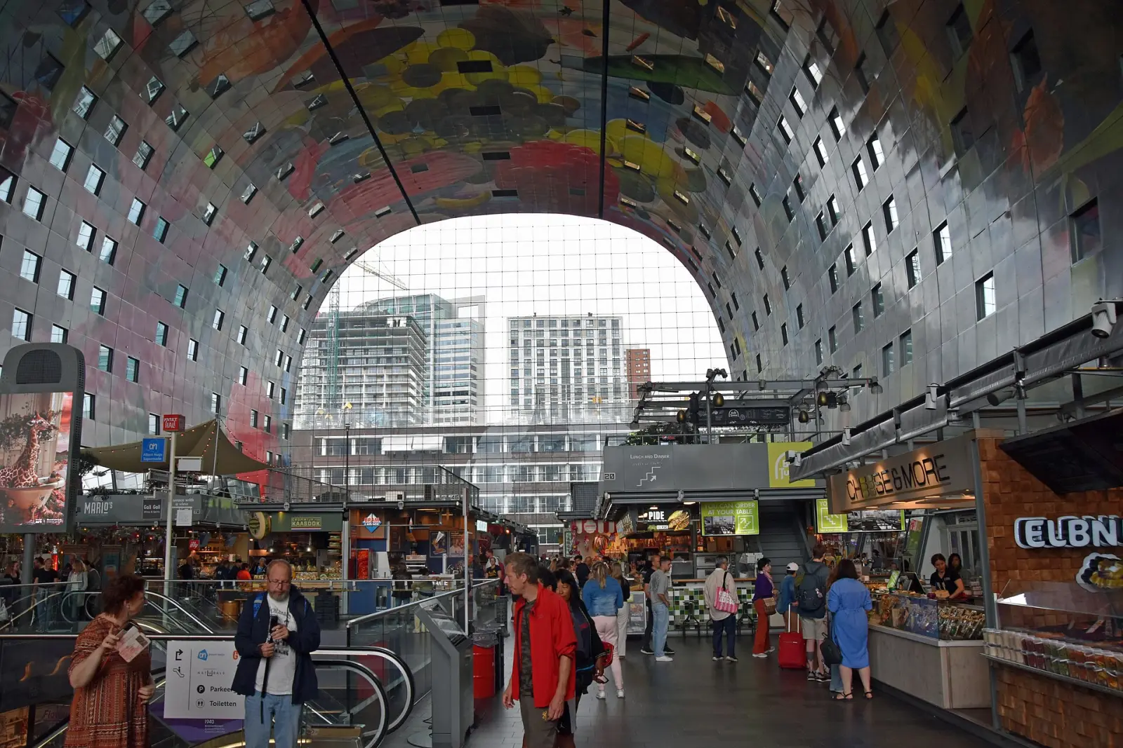 Inside the Markthal in Rotterdam, food stalls beneath the painted arched ceiling