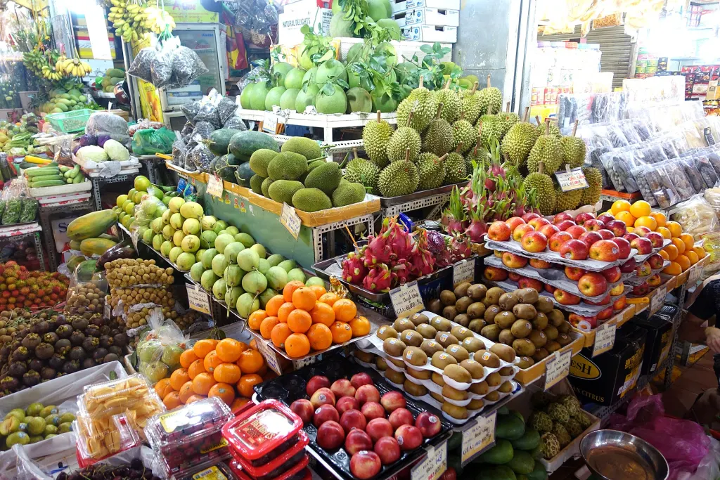 A fruit stall in Ben Thanh Market, Ho Chi Minh City, with dragon fruit, durian and citrus under handwritten price cards in dong